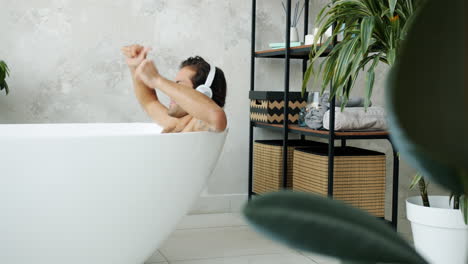 man enjoying music in bathtub