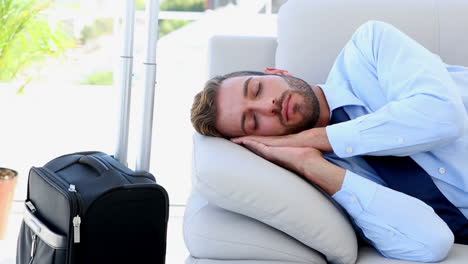 Businessman-sleeping-on-the-couch-waiting-to-go-on-a-trip