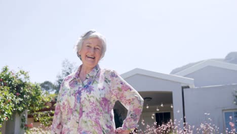 Happy-senior-woman-standing-in-the-garden