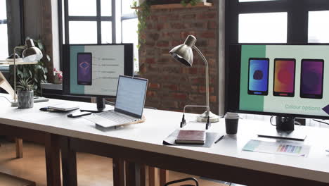 modern business workspace is equipped with multiple monitors, a laptop, and various office supplies