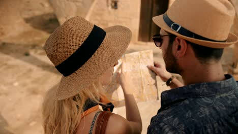 una pareja de turistas leyendo un mapa para obtener direcciones en grecia.
