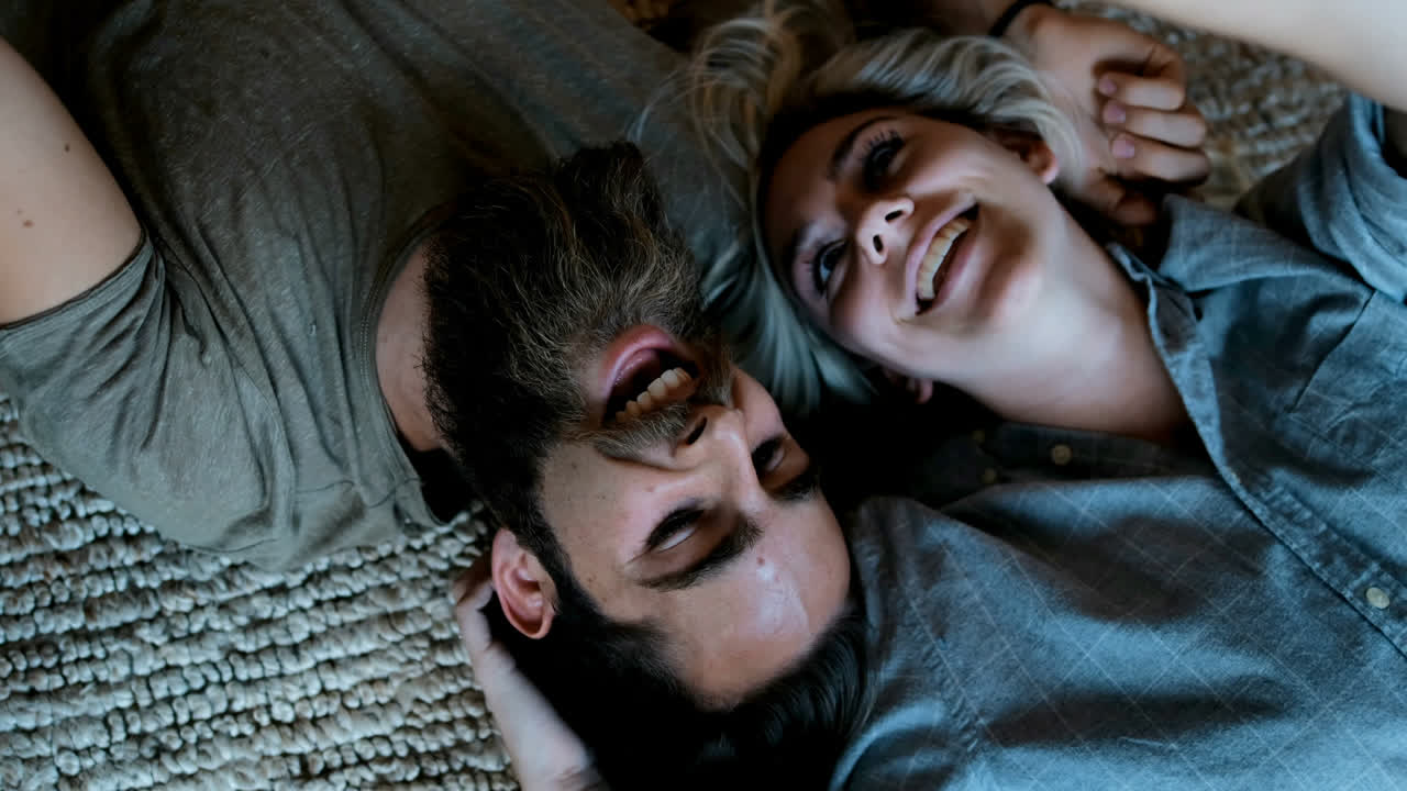 커플이 거실 4k에서 휴대폰으로 셀카를 찍고 있다