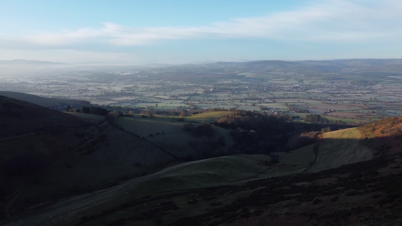 distantes capas brumosas de paisaje rural de valle de montaña de ensueño panorámico al amanecer vista aérea hacia adelante órbita derecha