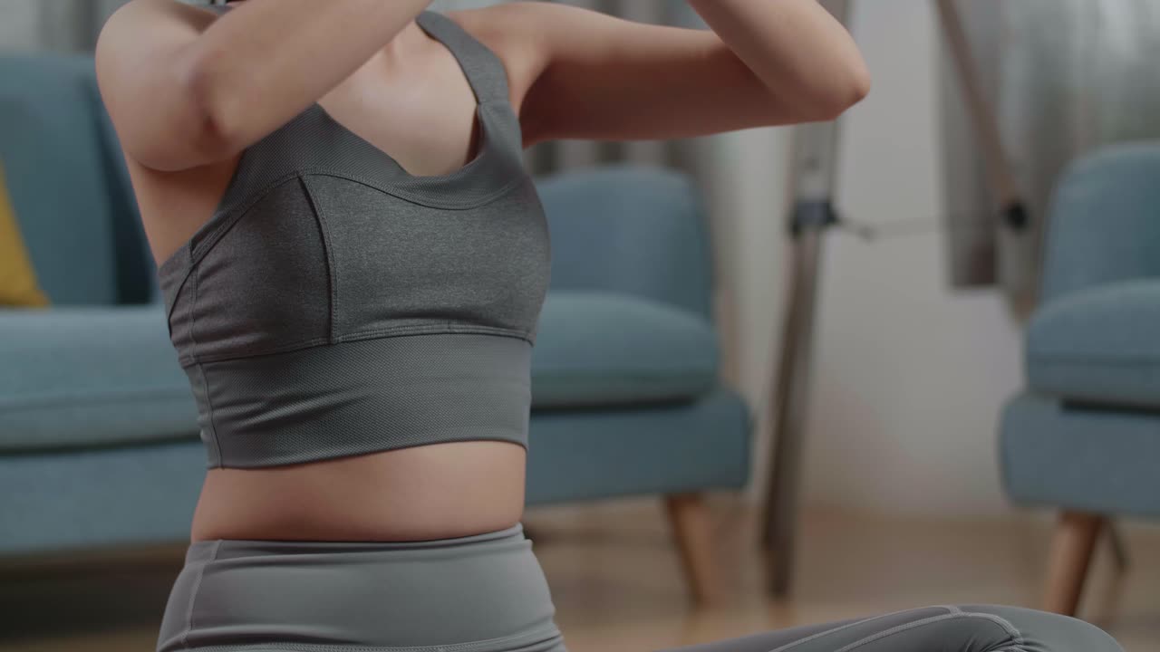 primer plano de una mujer atlética haciendo yoga en la postura de sukhasana durante el entrenamiento en la alfombra de yoga en casa. estilo de vida saludable, fitness, bienestar y atención plena