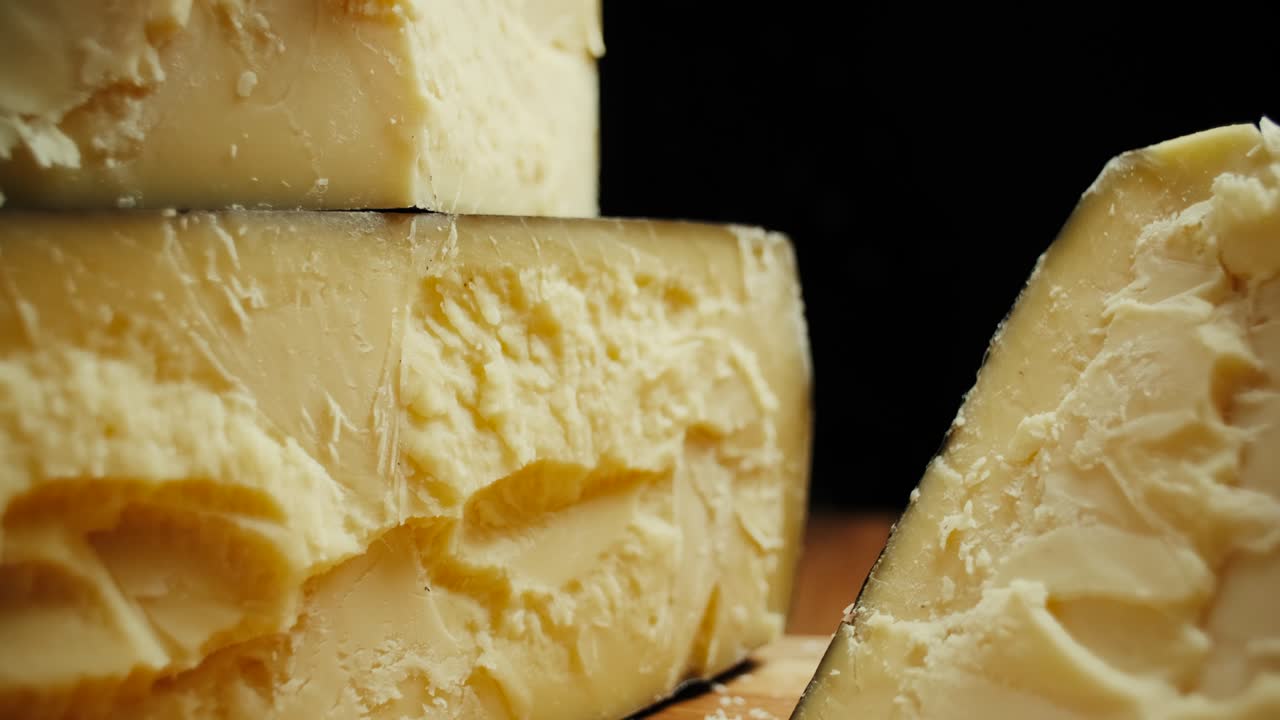 queso de cabeza dura media parmesano en tablero de madera. disparo de dolly-out