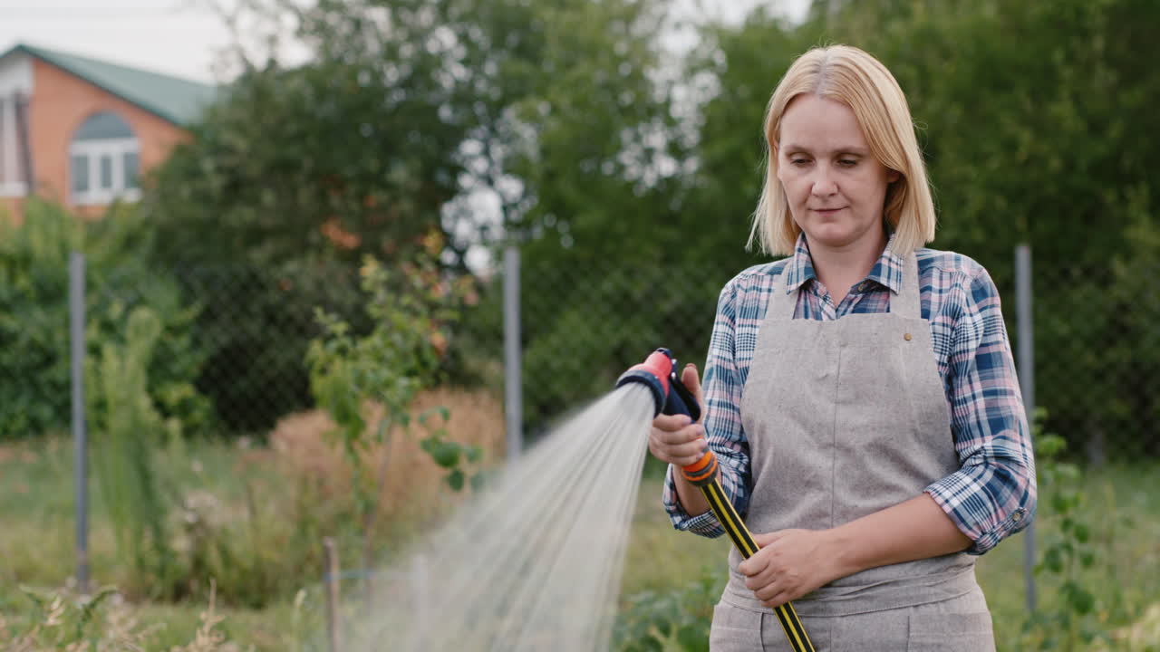 jardinero riega las plantas de la manguera de jardín 1