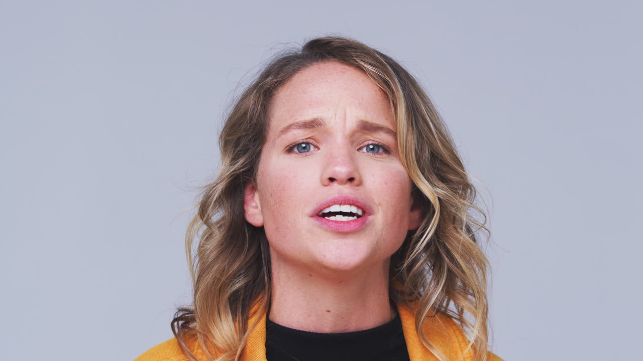 cabeza y hombros toma de estudio de una mujer enojada gritando a la cámara en cámara lenta