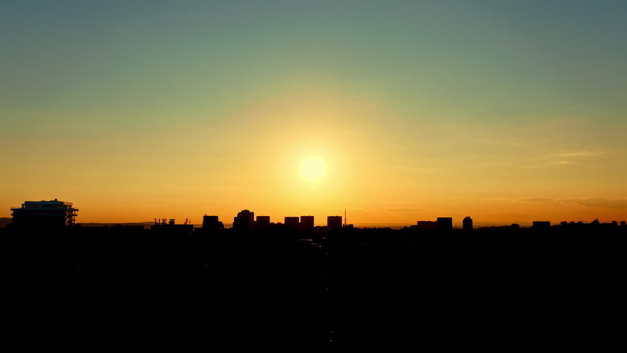 Atardecer sobre el horizonte de la ciudad con edificios silueteados contra un cielo brillante con la luz del atardecer.