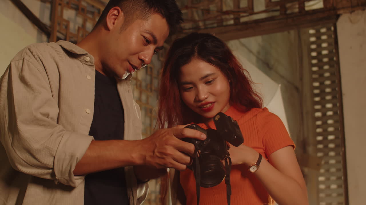 Asian Couple Checking Photos They Made in Abandoned Building