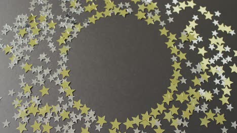 video of multiple gold and silver stars with copy space on black background