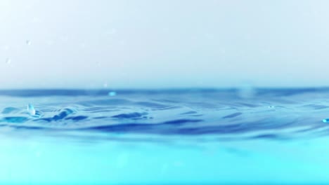 la superficie del agua limpia en cámara lenta llena la pantalla con agua salpicando la gota de agua y la superficie líquida ondeando con una burbuja de aire