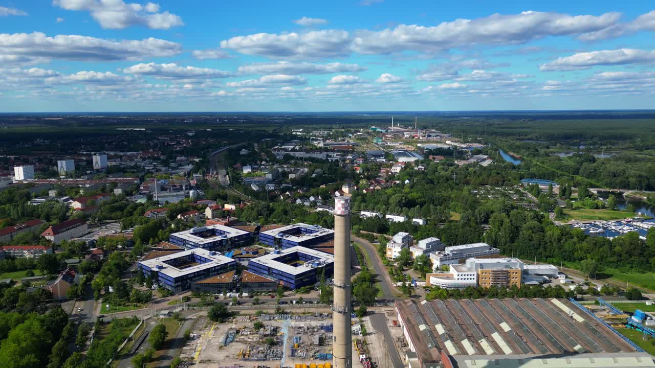 Hennigsdorf, Germany, showcasing residential areas, railway infrastructure and commercial buildings. Smooth aerial view flight descending drone