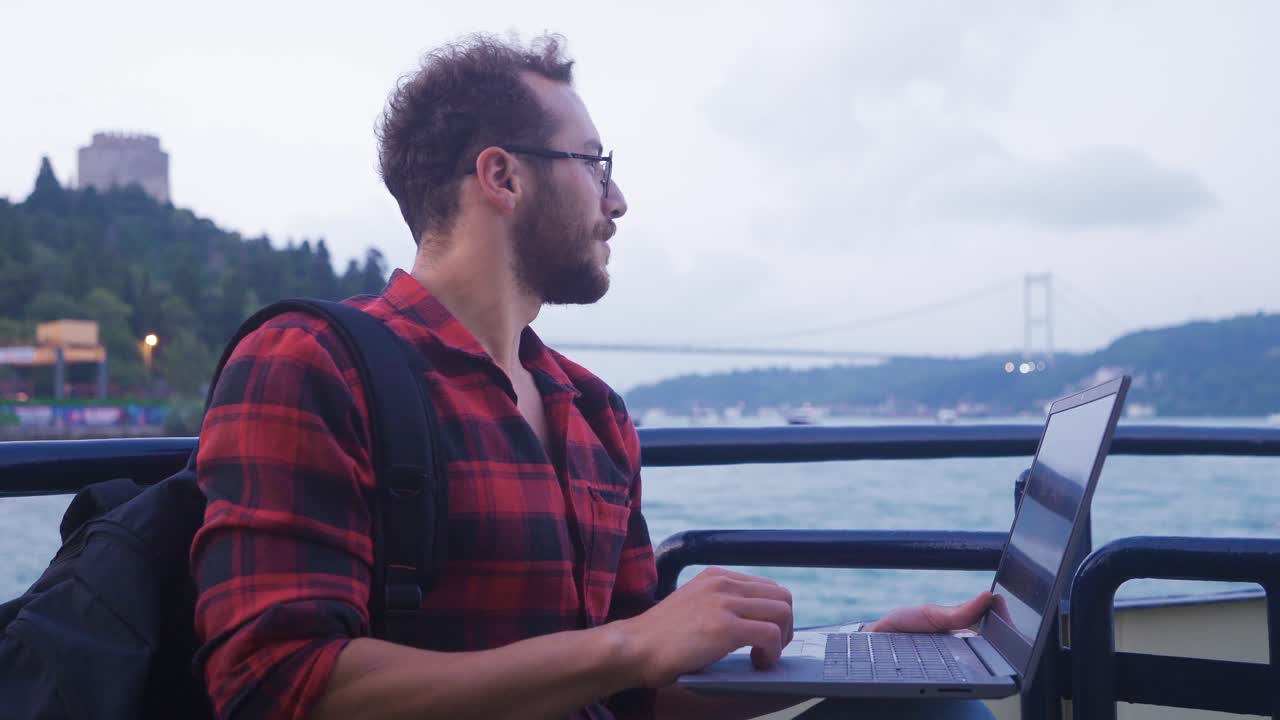 Man using laptop on ferry.