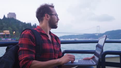 man using laptop on ferry.