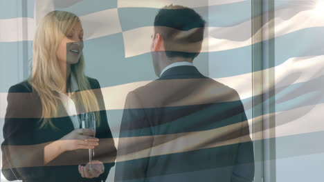 Waving-greece-flag-against-diverse-businessman-and-businesswoman-discussing-at-office