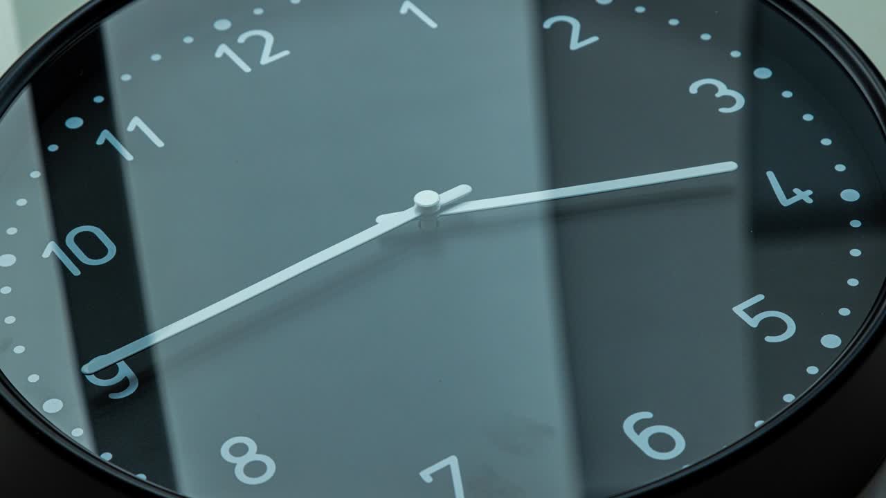 Time lapse on a modern black wall clock.  Close up to a wall clock
