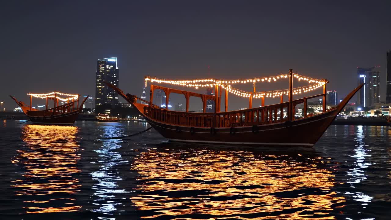 Traditional wooden dhows, adorned with festive lights, gracefully sail along Dubai Creek at night, creating a magical scene with illuminated buildings in the backdrop