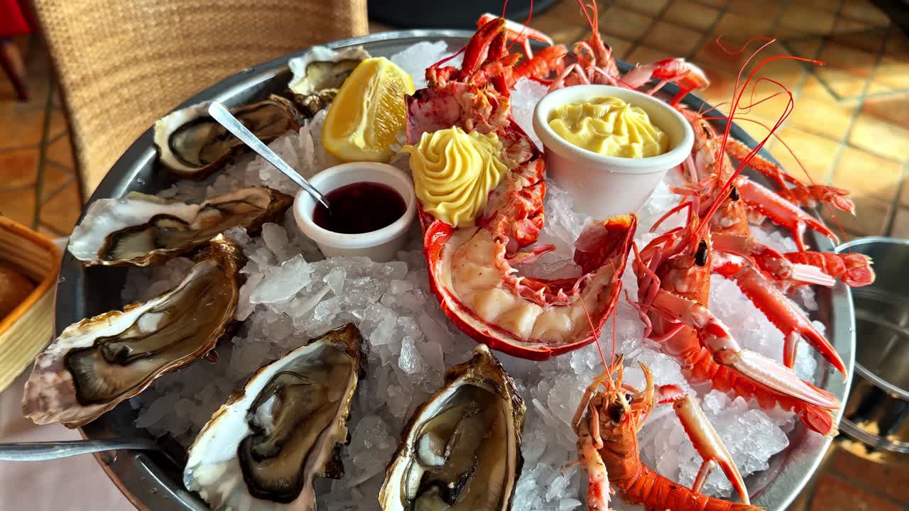 Seafood platter serving fresh oysters, lobster, and langoustines on ice