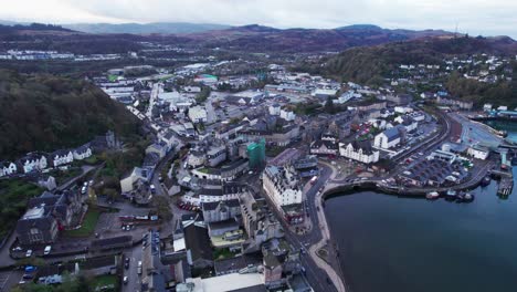 Establisher-aerial-of-town-of-Oban-in-Scotland,-view-of-Port-and-townscape