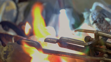 a blacksmith uses gas welding to melt a brass saxophone, resulting in destructive sparks and brightly coloured flames