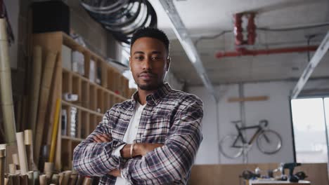 portrait of young male business owner in workshop for building sustainable bamboo bicycles