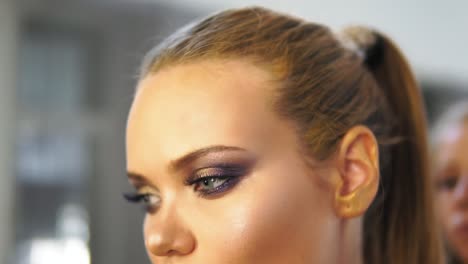 Close-up-shot-of-hair-stylist-brushing-a-model's-hair-while-making-hair-do.-Hairdresser-makes-hairstyle-for-the-model-close-up