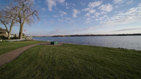 backyard-with-path-leading-to-a-fire-pit-and-a-lake-with-an-American-flag-waving