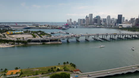 Drone-shot-of-boats-in-middle-of-the-bridges,-in-downtown-Miami-sunny-Florida