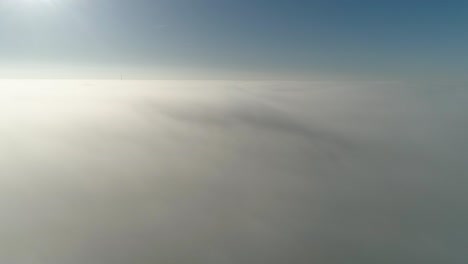 flight over misty clouds in morning sunlight with little glory and city scape under clouds