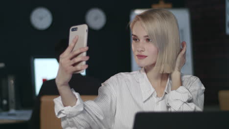 Atractiva-Mujer-De-Negocios-Haciendo-Selfie-En-Teléfono-Móvil-En-La-Oficina-Oscura