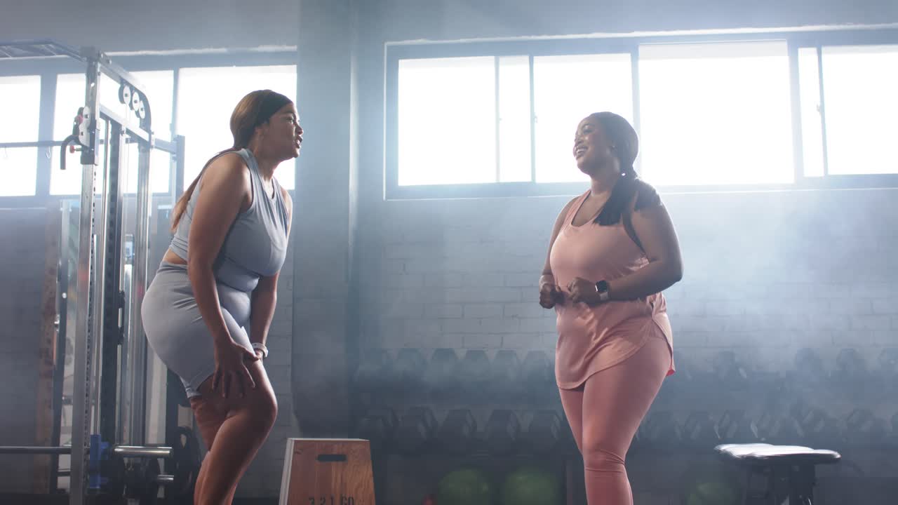 Diverse amiche in palestra dopo essersi salutate, riscaldamento e squat vicino al plyo box per l'allenamento