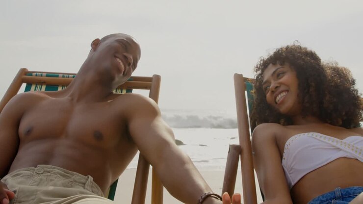 Vista frontale di coppia afroamericana che si diverte insieme sulla spiaggia 4k