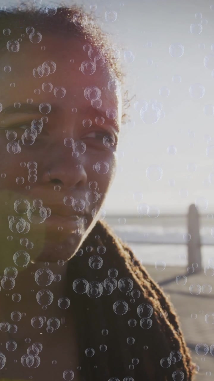 Animation of bubbles over woman drinking water on promenade