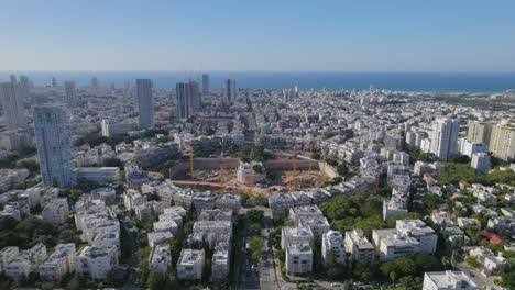 empuje aéreo a un proyecto de plaza de gran ciudad en construcción - costa en el fondo