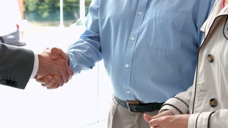 couple taking keys from businessman