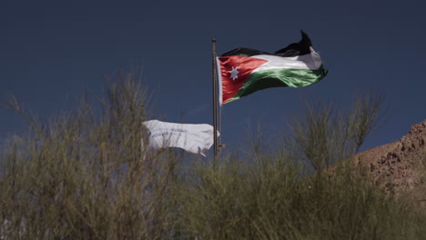 the national flag of jordan at the wadi rum visitors centre in the desert.