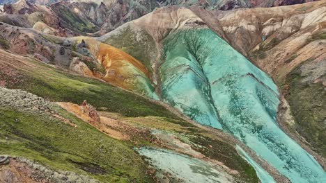 aerial drone forward medium view with slow bottom movement over grænihryggur, the green rock, in landmannalaugar, iceland