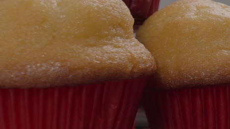 close-up of stacked golden muffins in red liners with a soft texture and a blurred background