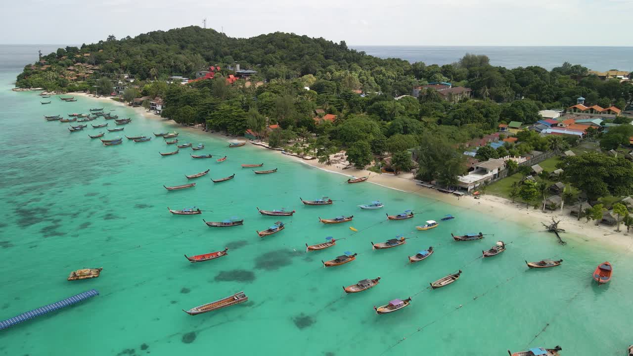 toma lenta de una playa llena de botes en la isla de ko lipe, tailandia en un día claro y brillante