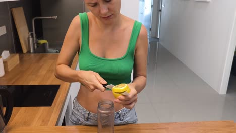 mujer preparando bebida de limón en la cocina