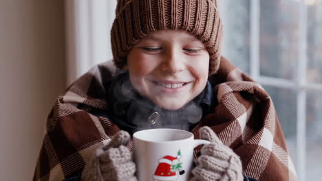 cozy winter scenes: child enjoys a steaming christmas drink