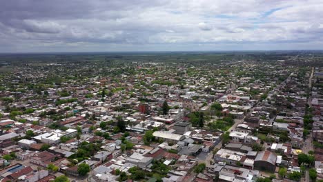 Forward-aerial-of-rural-town-and-flat-landscape-in-cloudy-Argentina