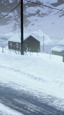 snowy road with cabin in the distance