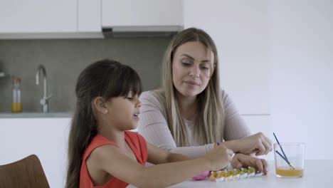 niña pequeña y su madre haciendo trabajos artesanales