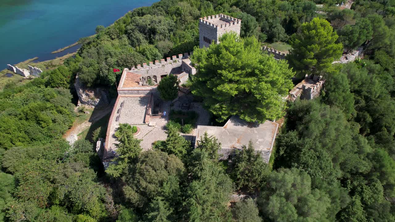 ciudad de butrint antigua fortaleza romana: un sitio del patrimonio de la unesco en una colina verde, rodeada de tranquilas aguas de un lago