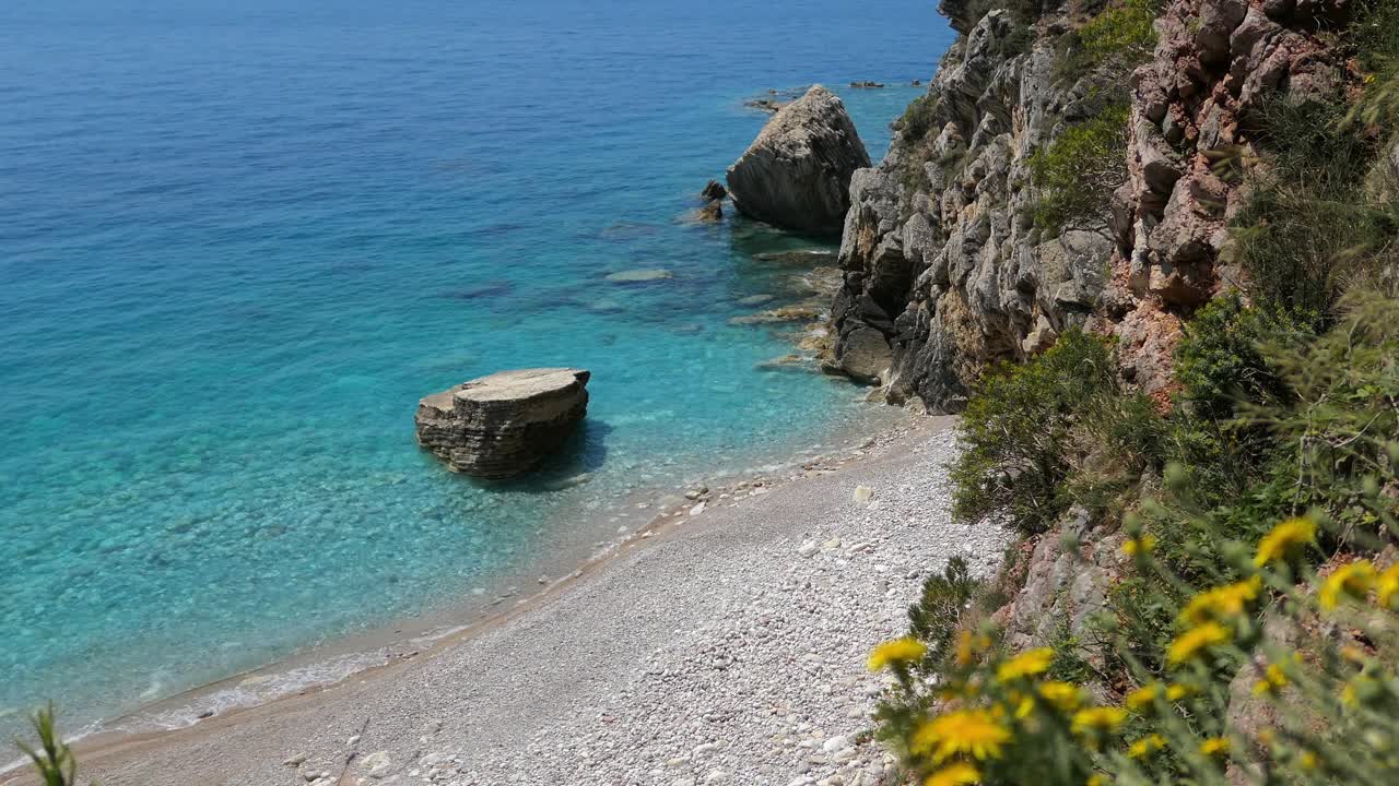 Spiaggia nascosta con acqua turchese e cristallina, Mediterraneo.