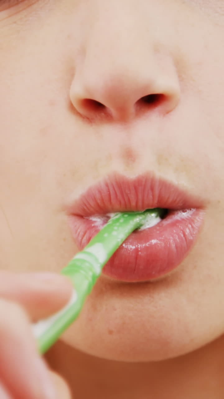 Portrait of woman brushing her teeth in bathroom