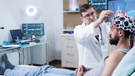 doctor in neuroscience making adjustments to brain sensors on patient