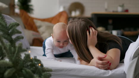los mejores momentos de la vida, una madre joven feliz y amorosa abraza a un hijo lactante, sobre una manta blanca como la nieve, sobre un fondo blanco. concepto de amor, familia y felicidad concepto: niños, niños, bebé, bebés