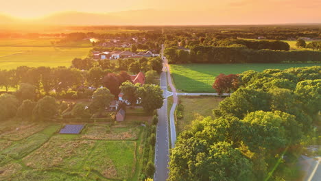 Sunset over countryside. A serene view of a countryside landscape at sunset, showcasing fields, homes, and lush greenery under warm light